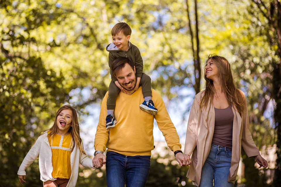 A family picture clicked outdoors on a walk.